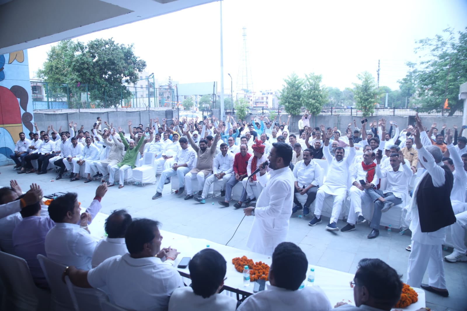नोएडा जनसभा में बड़ी संख्या में लोग रैली के समर्थन में हाथ उठाते हुए
