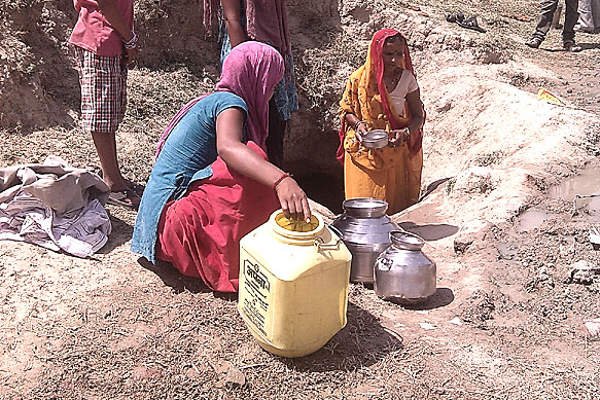 मुधारा जल संकट के कारण हैंडपंप पर पानी भरते ग्रामीण